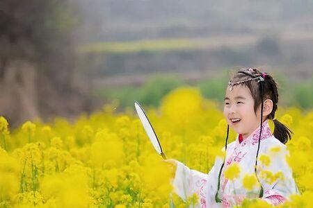 油菜地大笑的小男孩是女孩子吗